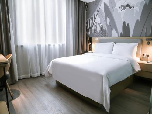 Un dormitorio con una gran cama blanca y una ventana en Thank Inn Chain Hotel Hebei hengshui wuqiang zhenxing road, en Hengshui