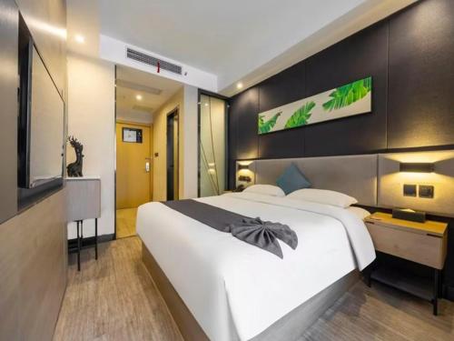 a bedroom with a large white bed and a television at PERO Hengyang Shigu Academy in Hengyang