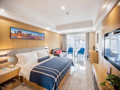 a hotel room with a bed and a television at LanOu Hotel Yellowstone Harbor Area Moore Cityland in Huangshi