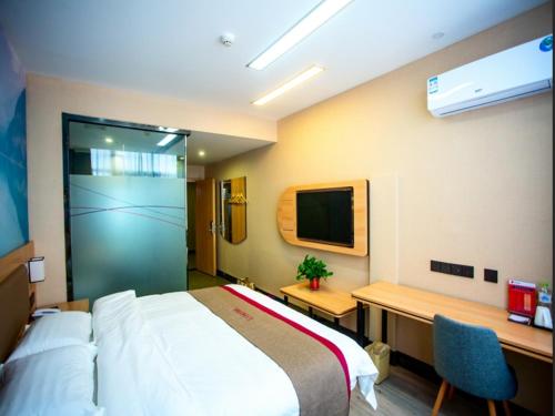 a bedroom with a bed and a desk and a tv at Thank Inn Plus Hotel Shandong Liaocheng Railway Station in Liaocheng