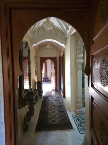 an archway in a room with a hallway with a piano at Barthélemy Guest House in Marrakech