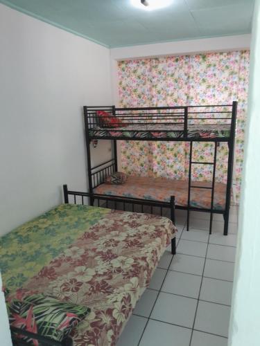 sypialnia z 2 łóżkami piętrowymi w pokoju w obiekcie Ravehei smile relais 2 moorea w mieście Afareaitu
