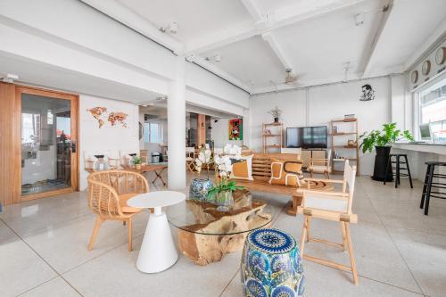 a living room with chairs and a table and a room at Unplugged at Bangrak Design Hostel in Bangkok