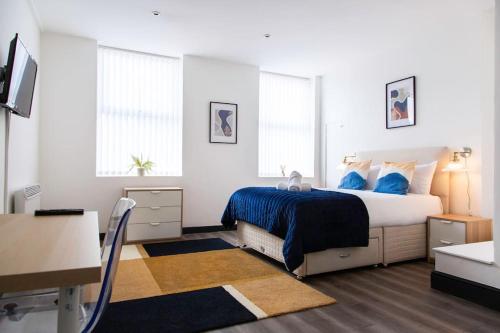 a bedroom with a large bed with blue pillows at Bootle(Liverpool) Modern 2Bed Ft in Bootle