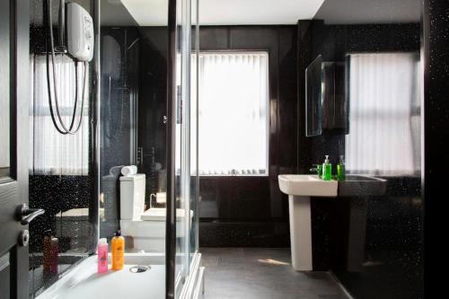 a bathroom with a shower and a tub and a sink at Bootle(Liverpool) Modern 2Bed Ft in Bootle