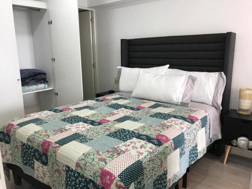 a bedroom with a bed with a quilt on it at Albano, Ocean view and pool near Miraflores and airport in Lima