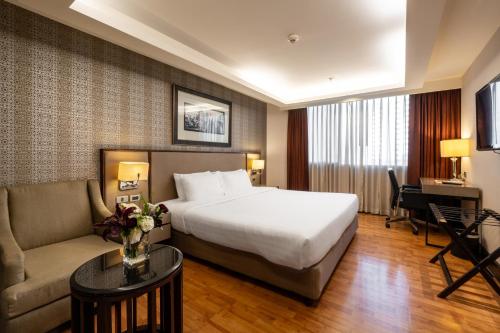 a hotel room with a bed and a couch at Rembrandt Sukhumvit - SHA Extra Plus in Bangkok