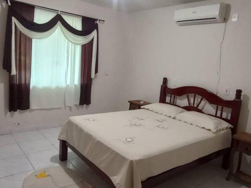 - une chambre avec un lit et une fenêtre dans l'établissement Sítio Ribeirão Bonito, à Pinheiral