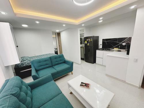 uma sala de estar com um sofá azul e uma cozinha em Apt nuevo 15min CC BuenavistValmundo TV50 Netflix em Barranquilla
