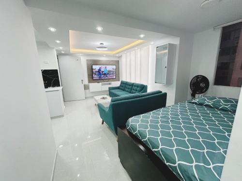 a bedroom with a bed and a couch and a tv at Apt nuevo 15min CC BuenavistValmundo TV50 Netflix in Barranquilla
