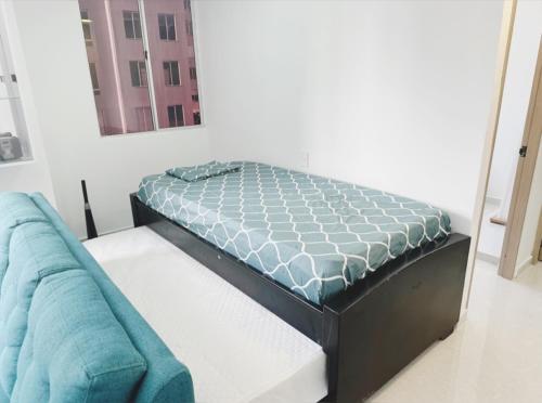 a bed in a room next to a couch at Apt nuevo 15min CC BuenavistValmundo TV50 Netflix in Barranquilla