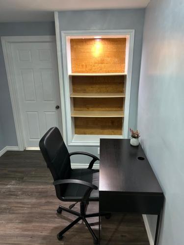 a black desk and a chair in a room at Cozy basement in Brampton in Brampton