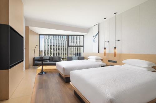 a hotel room with two beds and a flat screen tv at Fairfield by Marriott Shanghai Lingang Special Area in Shanghai