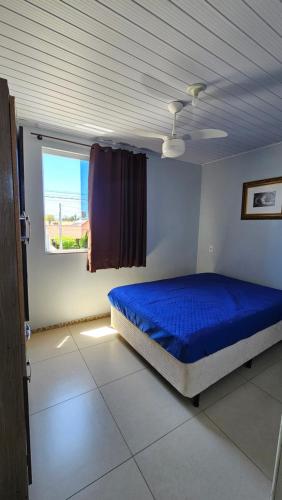 Un dormitorio con una cama azul y una ventana en Apartamentos GV, en Xangri-lá