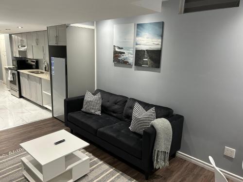 a living room with a black couch and a table at Cozy basement in Brampton in Brampton