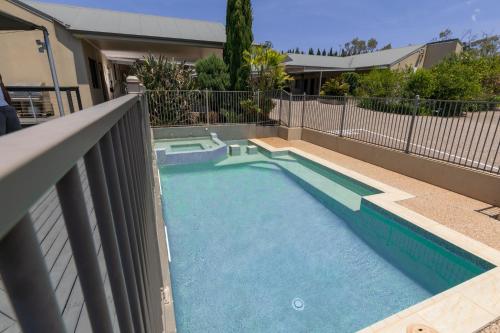 a swimming pool with a fence around it at Highfields Motel Toowoomba in Highfields