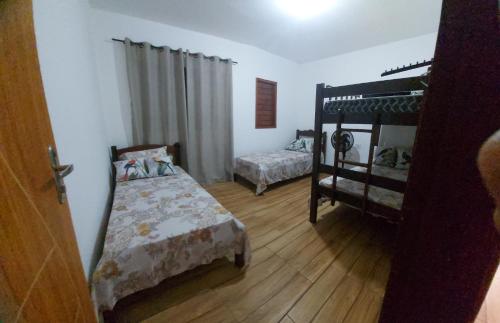 a bedroom with two beds and a bunk bed at Lugar tranquilo e aconchegante in Tibau do Sul