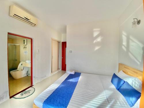 - une chambre avec un lit doté d'oreillers bleus et une salle de bains dans l'établissement Khách sạn 23 Thùy Vân - căn hộ 17D, à Vung Tau
