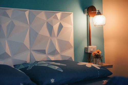a bedroom with a bed and a lamp and flowers at La Casa de Adry in Cali