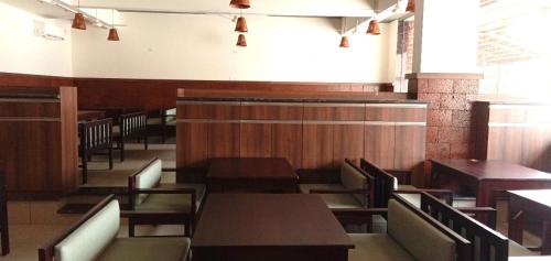 a dining room with wooden tables and chairs at Hotel Rays Inn and Pegs Family Restaurant in Dharmastala