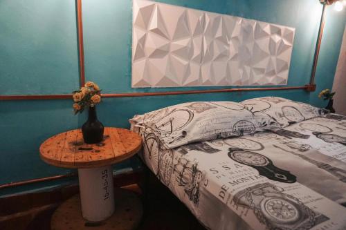 a bedroom with a bed and a table with a vase on it at La Casa de Adry in Cali