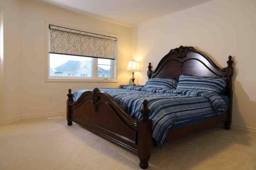 a large bed in a bedroom with a window at Povey Retreat Centre Wellington (Fergus Elora) in Fergus