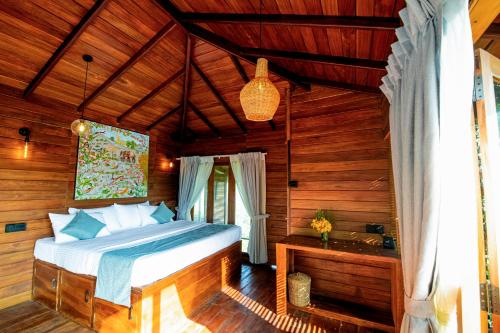 ein Schlafzimmer mit einem Bett in einem Holzzimmer in der Unterkunft Heavens Acres Lodge in Matale