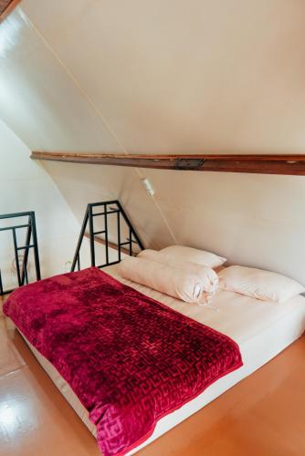 a bed with a red blanket on top of it at The Lavana Jejunten Bango Takengon in Takengon