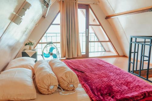 Takengon的住宿－The Lavana Jejunten Bango Takengon，配有枕头的床铺,位于带大窗户的房间里