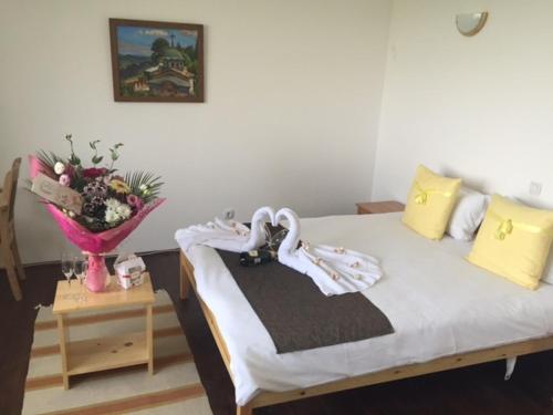 a bedroom with a bed and a vase of flowers at Арт комплекс Горски дом - Трявна in Tryavna