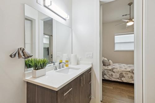 a bathroom with a sink and a mirror and a bed at Dallas Dreamscape in Dallas