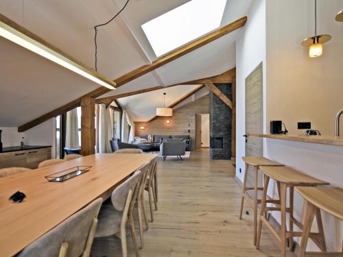 une salle à manger avec une longue table en bois et des chaises dans l'établissement Appartement rénové avec ski aux pieds, 4 chambres et prestations incluses à Courchevel - FR-1-613A-29, à Courchevel
