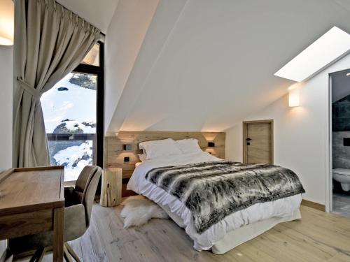 a bedroom with a bed and a desk and a window at Appartement rénové avec ski aux pieds, 4 chambres et prestations incluses à Courchevel - FR-1-613A-29 in Courchevel