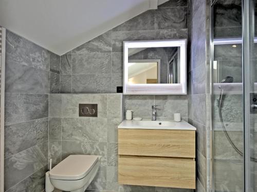 a bathroom with a toilet and a sink and a mirror at Appartement rénové avec ski aux pieds, 4 chambres et prestations incluses à Courchevel - FR-1-613A-29 in Courchevel