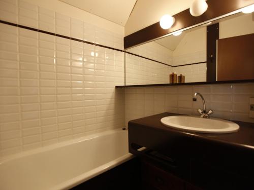 a bathroom with a sink and a mirror and a tub at Appartement Avoriaz, 2 pièces, 4 personnes - FR-1-314-269 in Morzine