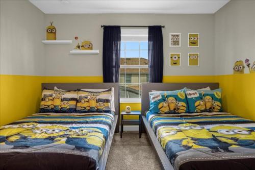 twee bedden in een kamer met gele muren bij 4 Bedrooms- 3 Bathrooms- Storey Lake 4817 Ll in Kissimmee