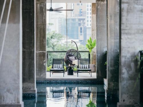 a pool of water with two chairs and a fan at Lloyd's Inn Kuala Lumpur in Kuala Lumpur
