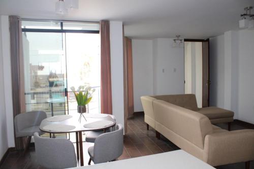 a living room with a couch and a table and chairs at Departamento en Chiclayo Peru Las Brisas de Cix in Chiclayo