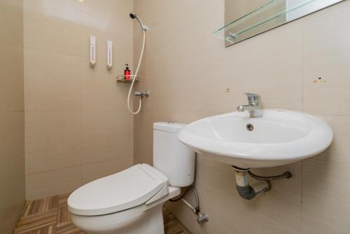 een badkamer met een wit toilet en een wastafel bij RedDoorz Plus @ Cideng Barat in Jakarta