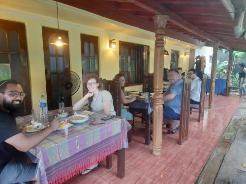 een groep mensen die aan een tafel zitten bij Sea Bay Inn Tangalle in Tangalle