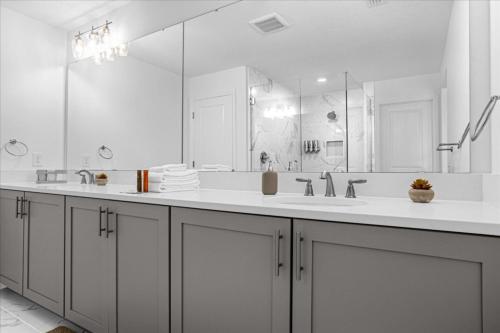 a white bathroom with two sinks and a large mirror at 3 Bedrooms- 2,5 Bathrooms- Festival 1880 Sa in Davenport