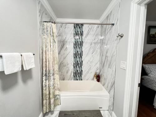 ein Bad mit einer Badewanne und einem Duschvorhang in der Unterkunft Ranch House North Decatur 5 mins to Emory University in Decatur