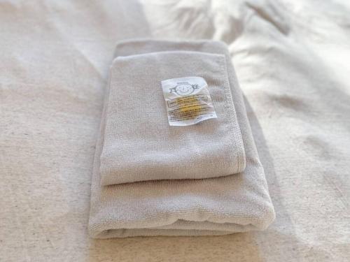 a pile of towels sitting on top of a bed at 川の音を聴きながら非日常体験を-伊豆の川辺に佇む小さなアパート-一人旅歓迎 in Izu