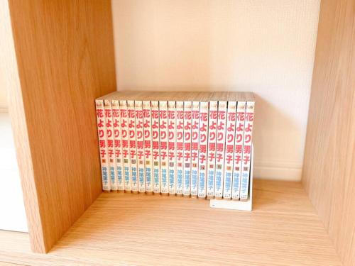 a room with a rack of books on the floor at 川の音を聴きながら非日常体験を-伊豆の川辺に佇む小さなアパート-一人旅歓迎 in Izu