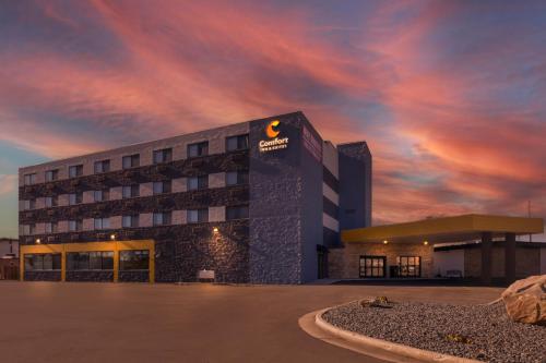 a hotel building with a cloudy sky in the background at Comfort Inn & Suites in Beaver Dam