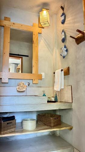 a bathroom with a counter with a mirror and baskets at SHANTI SURF CAMP in El Paredón Buena Vista