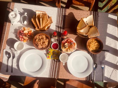 a table topped with white plates and bowls of food at Ella Rock Grun Cottage in Ella