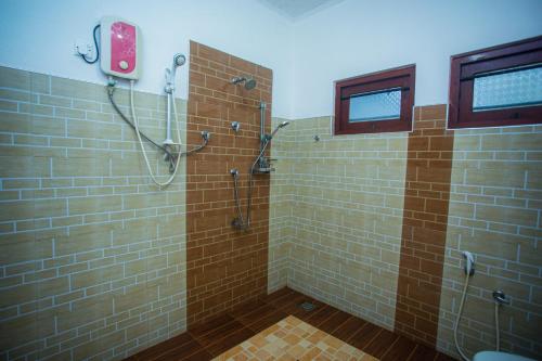 a bathroom with a shower with brown tile at Villa Greenjay Ahangama in Ahangama