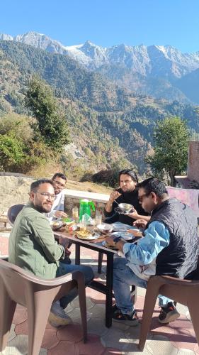 a group of men sitting at a table eating food at Kareri Wayfarer in Kareri