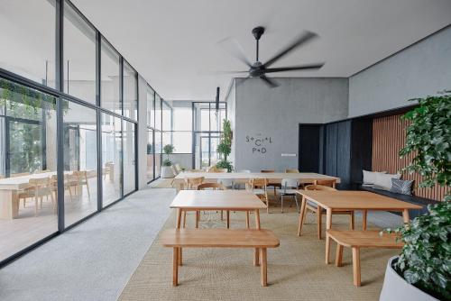 a dining room with tables and benches and windows at Lloyd's Inn Kuala Lumpur in Kuala Lumpur
